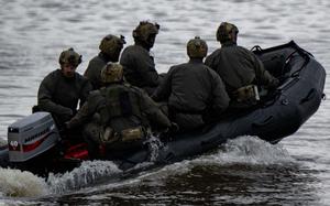 Six special operators ride in a boat.