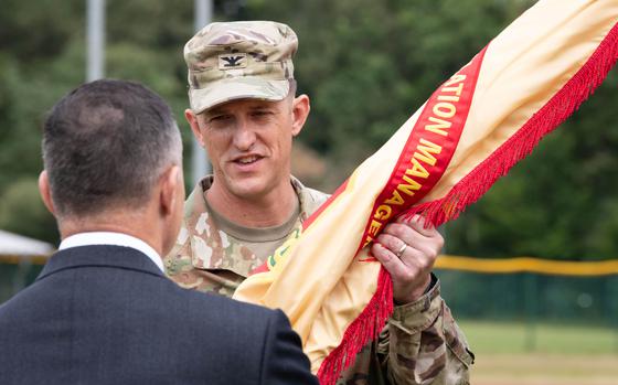 Col. Jeffery Higgins takes the colors during a ceremony in Kaiserslautern, Germany, on July 11, 2024, in which he assumed command of U.S. Army Garrison Rheinland-Pfalz.