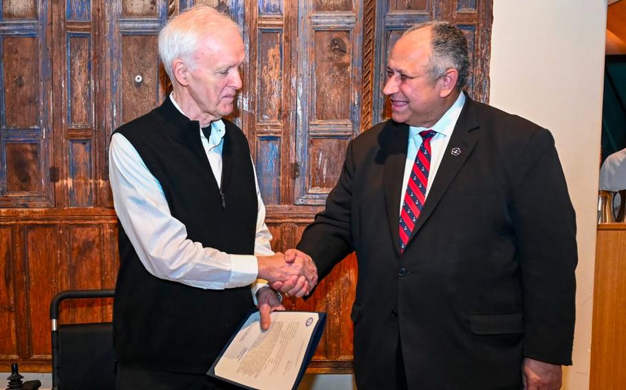 Carlos Del Toro shakes hands with Robert Kerrey.