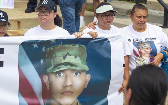 Sister Jennifer Ramirez, left, and Lourdes Lara, mother of Chrys Carvajal, the 19-year-old National Guard member killed over the July Fourth weekend, hold a banner with Carvajal's photo on it during a rally for peace at Riis Park in the Belmont-Cragin neighborhood of Chicago on July 24, 2021. 