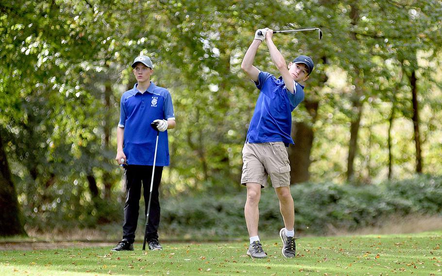 Ramstein's Christian McHugh drives off the 12th tee on Oct. 13, 2023, during the second day of the DODEA European golf championships at Woodlawn Golf Course on Ramstein Air Base, Germany. Watching, at left, is Royal teammate Tyler Hacker.