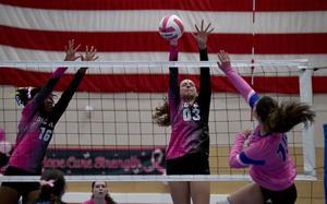 Wiesbaden's Briahna Arroyo goes for a block of a spike by Ramstein's Lauren Meusel during a match on Oct. 19, 2024, at Ramstein High School on Ramstein Air Base, Germany. Warrior Aniyah Brown, left, tries to help her teammate at the net.