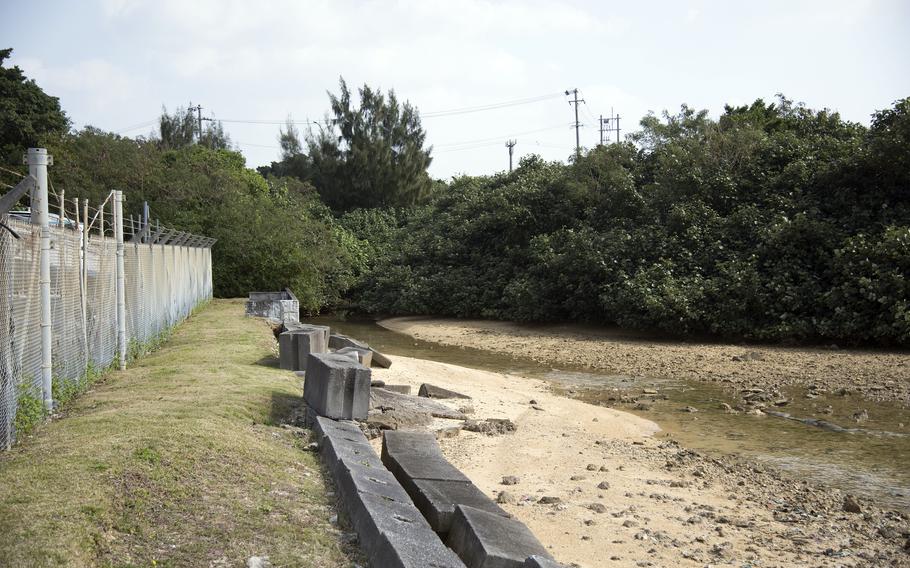 A canal is shown next to the fence surrounding Kadena Air Base. 