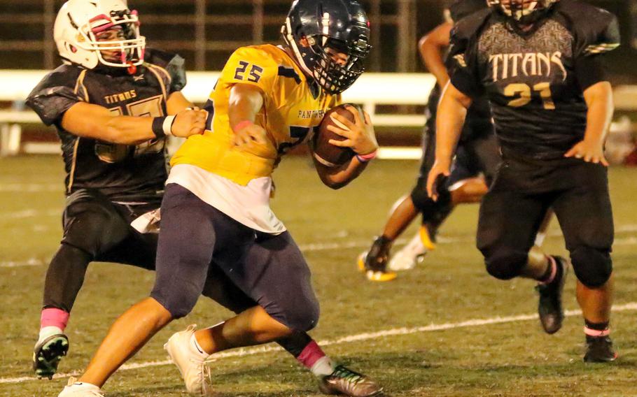 Guam High running back Randy Angoco tries to work his way free from Tiyan defenders.