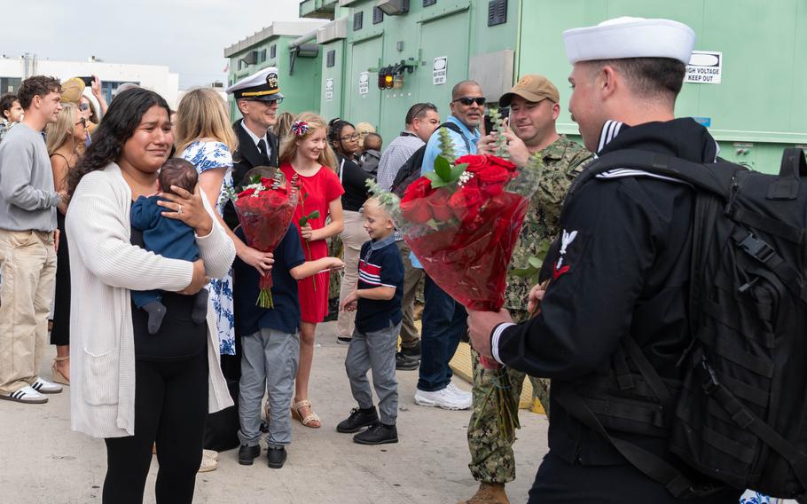 Quartermaster 3rd Class Christian Sanford reunites with his wife and newborn baby 