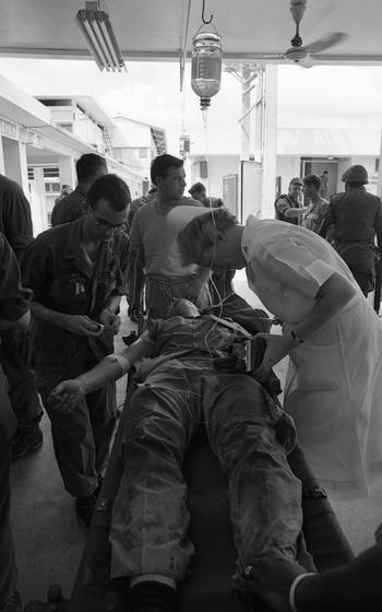 A photographer’s hand is examined by a nurse at a hospital