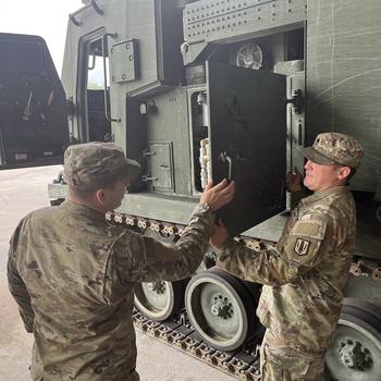 Soldiers inspect their M270A2 Multiple Launch Rocket System