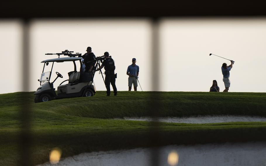 A sniper team is set up next to golfers as Donald Trump speaks at Trump National Golf Club in Bedminster, N.J.