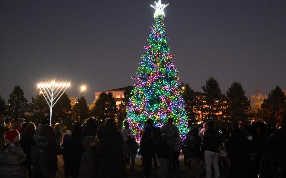 Andrews community members watch as a Christmas tree and menorah light up