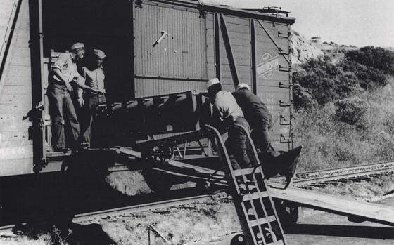 This image provided by Naval History and Heritage Command, shows African American Sailors of a naval ordnance battalion unloading aerial bombs from a railcar, circa 1943/44, in Port Chicago, Calif. The U.S. Navy has exonerated 256 Black sailors who were found to be unjustly punished in 1944 following a horrific port explosion that killed hundreds of service members and exposed racist double standards among the then-segregated ranks. (Naval History and Heritage Command/National Park Service via AP)