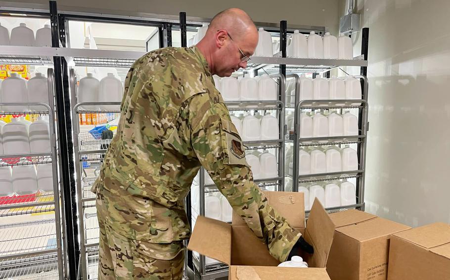 Air Force Col. Richard McElhaney, commander of the 374th Airlift Wing, restocks milk at the commissary on Yokota Air Base, Japan, on Aug. 9, 2024, after a lightning strike caused a power outage that ruined about $50,000 in food products.