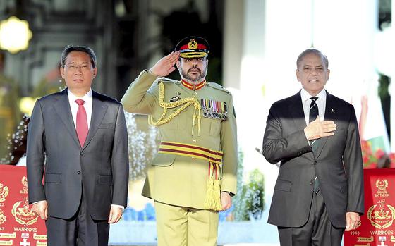 In this photo released by the Press Information Department, visiting China's Premier Li Qiang, left, and Pakistan's Prime Minister Shehbaz Sharif attend a welcome ceremony, in Islamabad, Pakistan, Monday, Oct. 14, 2024. (Press Information Department via AP)