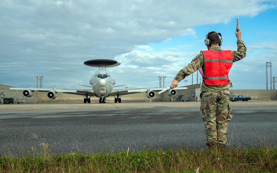 Senior Airman Christopher Burkins marshalls an E-3 Sentry assigned to the 961st Airborne Air Control Squadron at Kadena Air Base, Okinawa, Jan. 17, 2024. 