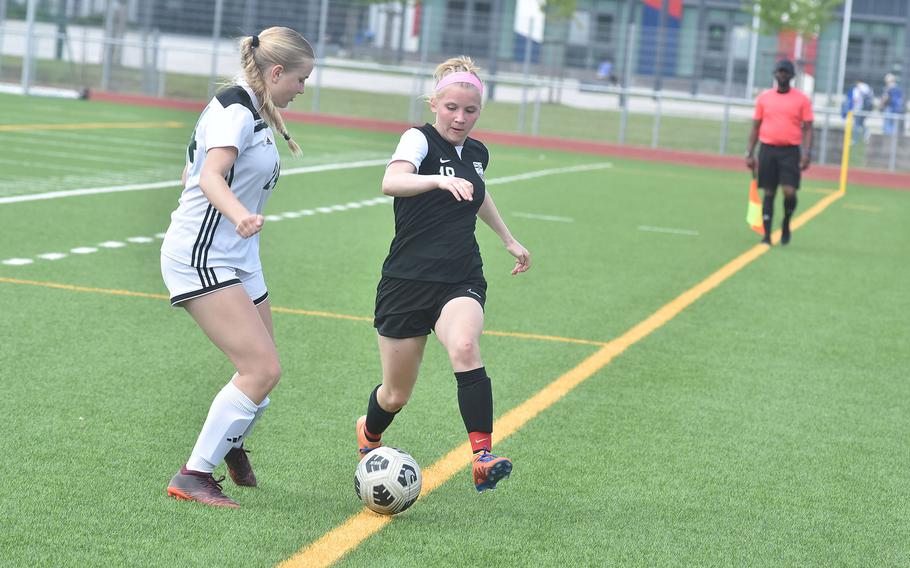 Stuttgart's Regan Stewart deftly navitages the sideline while harried by SHAPE's Fiona Rahlfs on Monday, May 20, 2024, at the DODEA European Division I girls soccer championships at Ramstein Air Base, Germany.