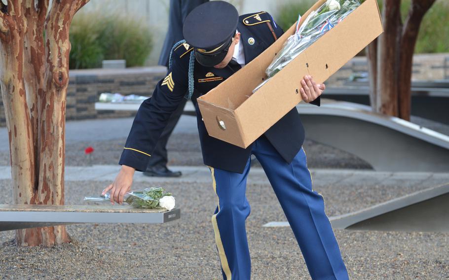 Members of the ceremonial guard on Wednesday, Sept. 11, 2024, place flowers on the 184 benches with the names of those who were killed at the Pentagon during the Sept. 11, 2001, terrorist attacks. 