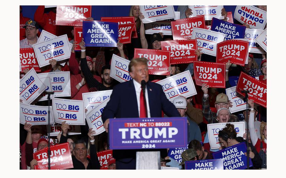 Supporters of Republican presidential candidate and former President Donald Trump hold up signs as he speaks during a campaign event at Greensboro Coliseum on March 2, 2024, in Greensboro, North Carolina. 