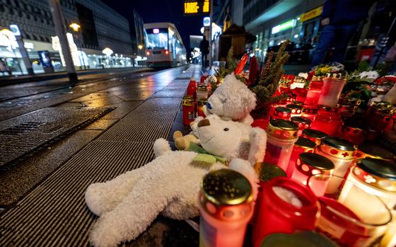 Teddy bears were laid together with candles near the Christmas market, where a car drove into a crowd on Friday evening, in Magdeburg, Germany, Sunday, Dec. 22, 2024. (AP Photo/Michael Probst)