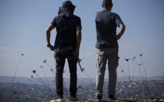 Israelis observe the damaged buildings in a village in southern Lebanon as they stand near the Israeli-Lebanese border, during the ceasefire between Israel and Hezbollah, in northern Israel, Saturday, Nov. 30, 2024. (AP Photo/Leo Correa)