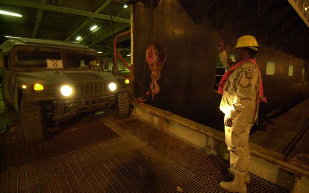 HED: Homeward bound, 2004

Shu'aibah Port, Kuwait, Jan. 28, 2004: Spc. Devel Brook, from the 771st Maintenance Company, directs a Humvee onto the Northern Lights, a civilian ship docked in Kuwait. The port is running 24-hour operations as equipment of units ending their deployment heads home, and gear of incoming units is coming in. From 975,000 to 1.3 million pieces of equipment will arrive at the port this year as deployments to Iraq , exceeding 2003s numbers, the first year of Operation Iraqi Freedom.

Read the 2004 article and check out additional photos here. 
https://www.stripes.com/migration/unit-is-gearing-up-for-troop-rotation-at-port-in-kuwait-1.16148

META TAGS: Wars on Terror; logistics; Operation Iraqi Freedom; U.S. Army;