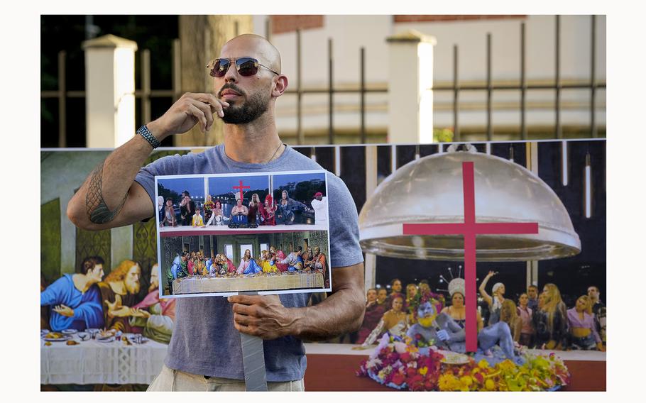 Social media influencer Andrew Tate gestures during a protest decrying a segment of the Paris Olympics opening ceremony, near the French Embassy in Bucharest, Romania, Sunday, July 28, 2024. 