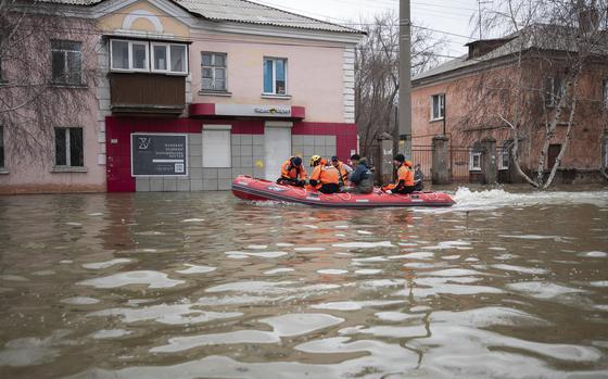 Emergency workers and police ride a boat during evacuations in a ...