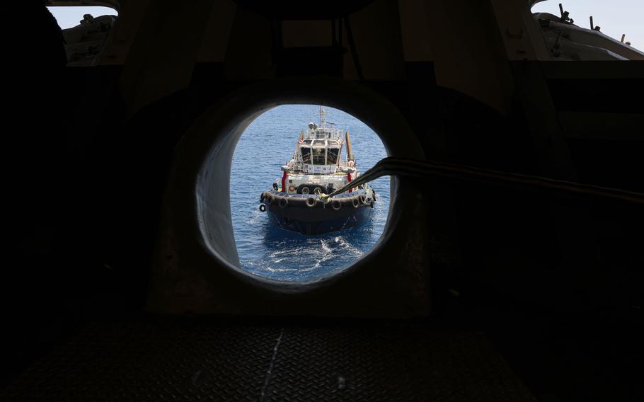 A tugboat positioned in front of the ship’s forecastle assists in maneuvering the amphibious assault ship USS Wasp into Souda Bay, Greece, July 8, 2024, for a port call.