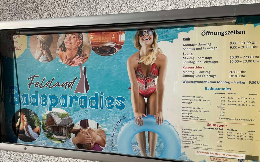 Entrance sign with times and prices at a swimming complex with indoor and outdoor pools.