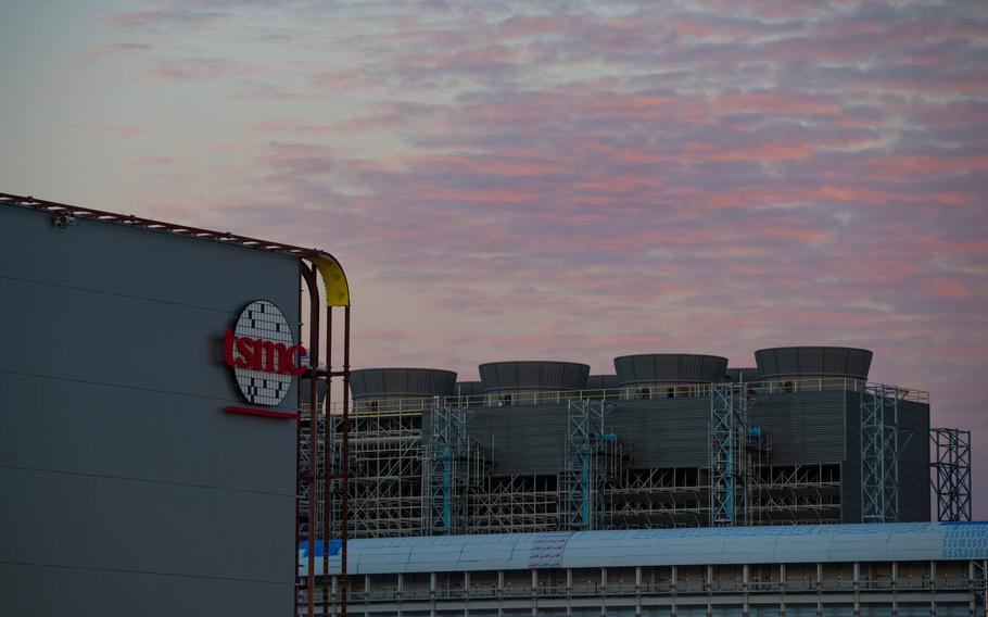 The bottom half of the image is taken up by a TSMC manufacturing facility while the top half is a sunset or sunrise. 