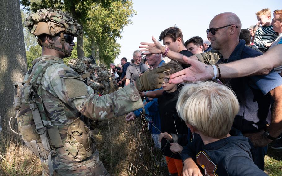 A soldier with the 101st Airborne Division hands out unit memorabilia to spectators at an air assault demonstration in Eerde, Netherlands, on Tuesday, Sept. 17, 2024. The event was held to mark the 80th anniversary of Operation Market Garden.