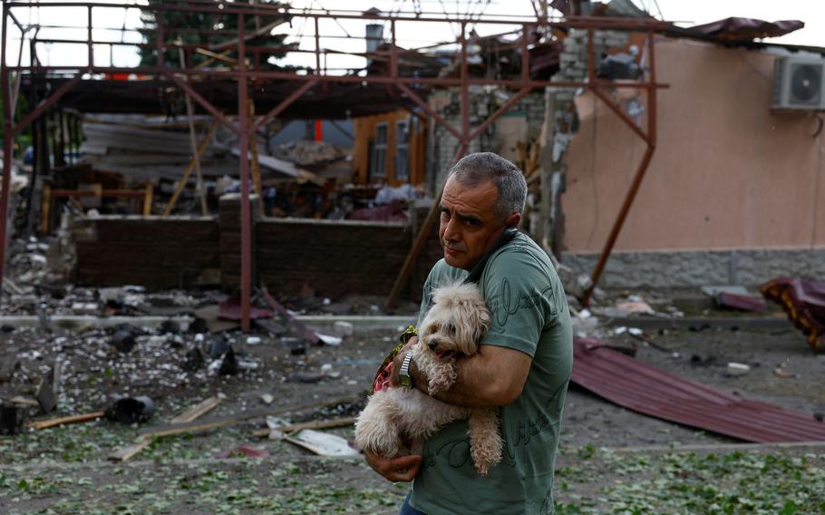 Vahe Ohandzanian, 54, holds a dog next to his cafe heavily damaged by a Russian air strike, amid Russia’s attack on Ukraine, in Kharkiv, Ukraine, on Wednesday, May 22, 2024. 