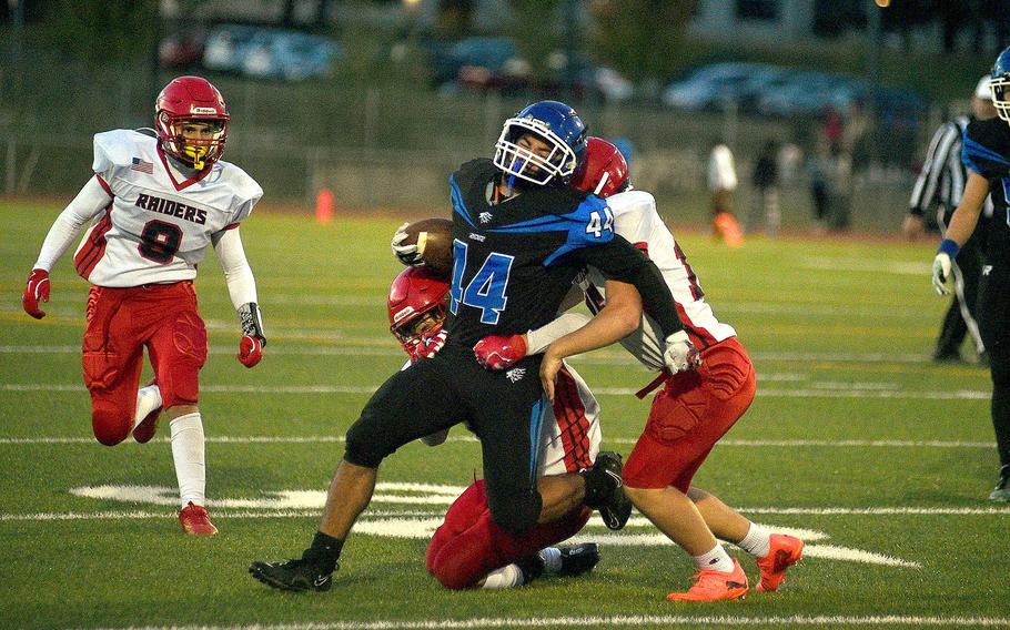 Ramstein running back Nathan Rutlege tries to shed the tackles of Kaiserslautern defenders John Westad, behind Rutlege and River Foulks, right, during a Sept. 13, 2024, game at Ramstein High School on Ramstein Air Base, Germany.