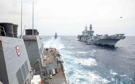 The guided-missile destroyer USS Russell, left, sails past the Italian  frigate ITS Alpino, center, and aircraft carrier ITS Cavour in the South China Sea, Sept. 9, 2024.