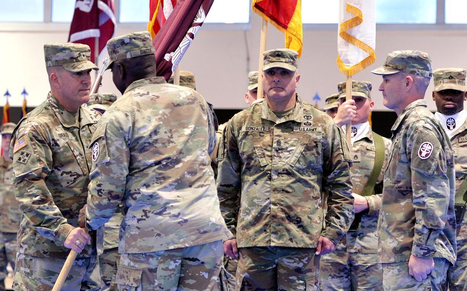 Brig. Gen. Roger Giraud takes the Medical Readiness Command, Europes guidon from Lt. Gen. R. Scott Dingle, the Surgeon General of the Army and commander of U.S. Army Medical Command, at a ceremony in Sembach, Germany, Oct. 26, 2023. At right is the outgoing commander Brig. Gen. Clinton Murray, in the center is Command Sgt. Maj. Jesus Gonzalez.