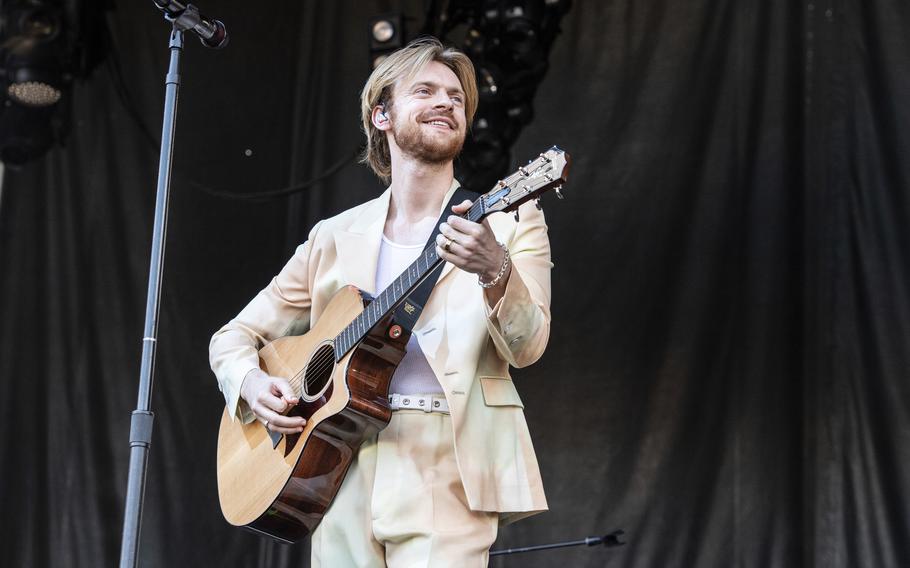 A man plays a guitar on stage.