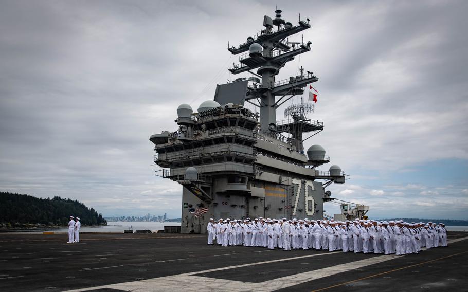 Sailors muster before manning the rails aboard the flight deck of the USS Ronald Reagan during the ship’s transit through the Puget Sound toward its new homeport at Naval Base Kitsap in Bremerton, Wash., Aug. 13, 2024. 