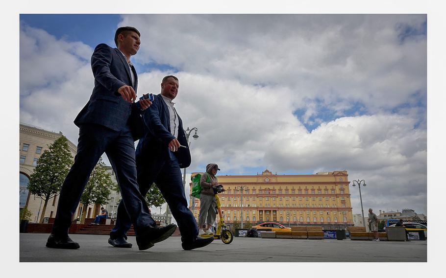 Men walk in front of the headquarters of Russia's Federal Security Services in central Moscow on Aug. 28, 2023. 