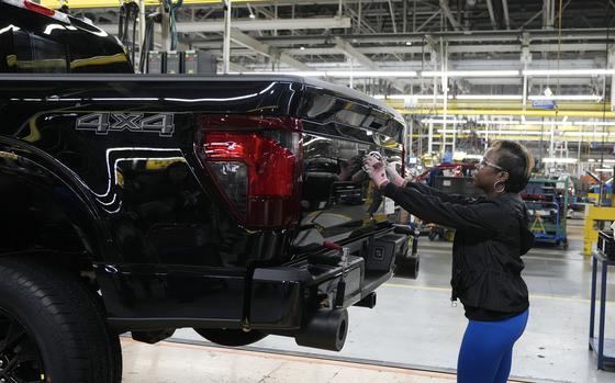 FILE - Assembly line worker Lashunta Harris applies the Ford logo on a 2024 Ford F-150 truck being assembled at the Dearborn Truck Plant, April 11, 2024, in Dearborn, Mich. On Friday, June 5, 2024, the U.S. government issues its June jobs report. 