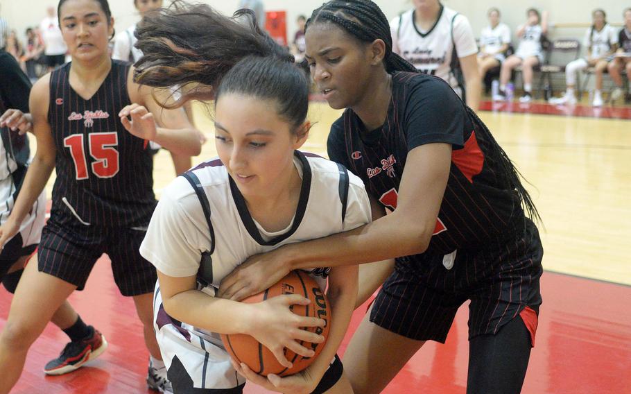 Matthew C. Perry's Kiki Rodriguez battles Nile C. Kinnick's Kamiyah Dabner for the ball during Friday's DODEA-Japan girls basketball game. The Red Devils won 37-14.