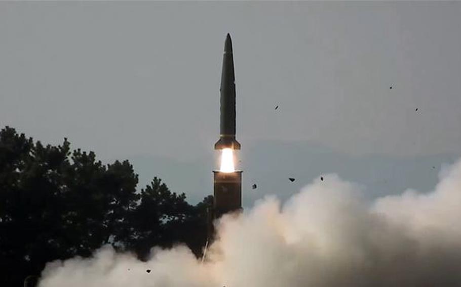 A ballistic missiel, seen from a distance, is fired into the sky.