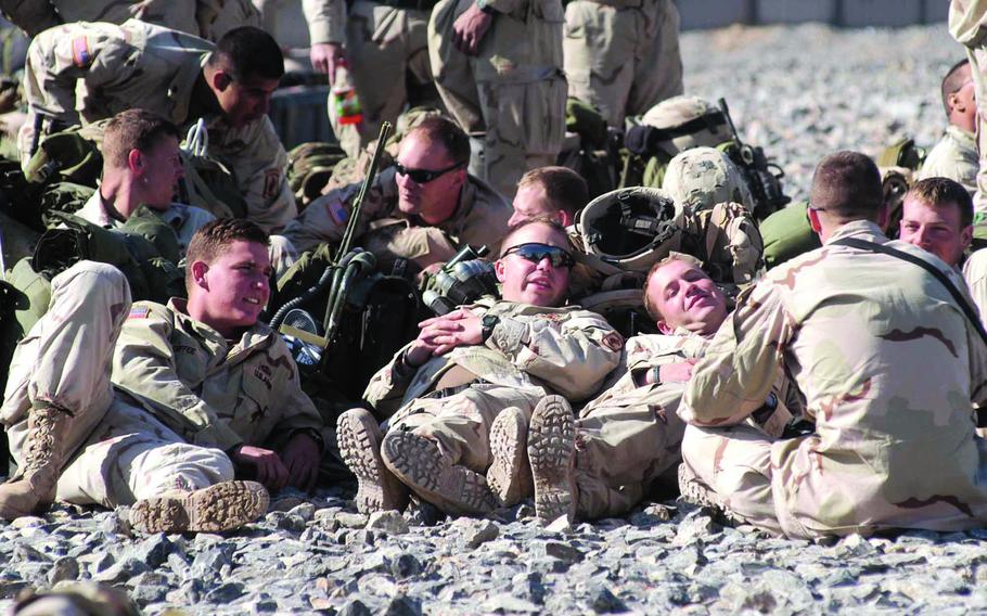 Soldiers relax on a helicopter landing pad