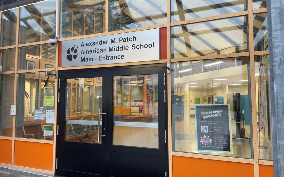 A sign reading “Alexander M. Patch American Middle School Main Entrance” above doors. 