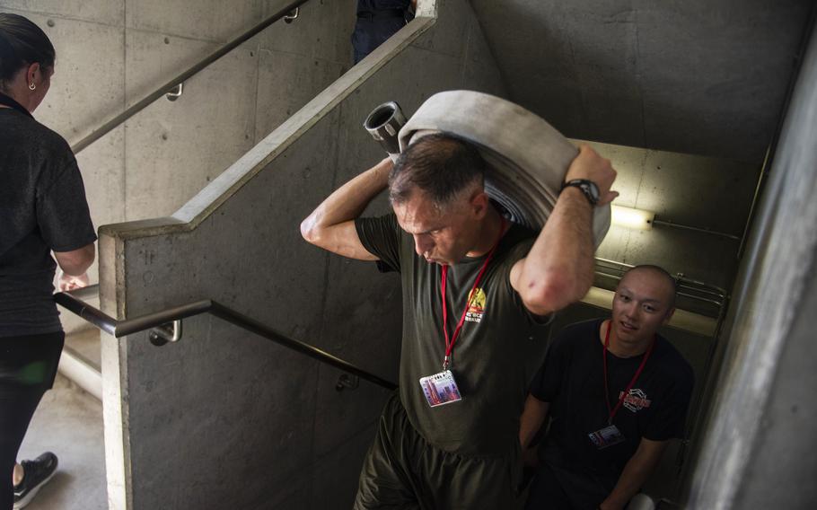 Marines, sailors and base residents take part in the 9/11 memorial stair climb at Marine Corps Air Station Iwakuni, Japan, Wednesday, Sept. 11, 2024.