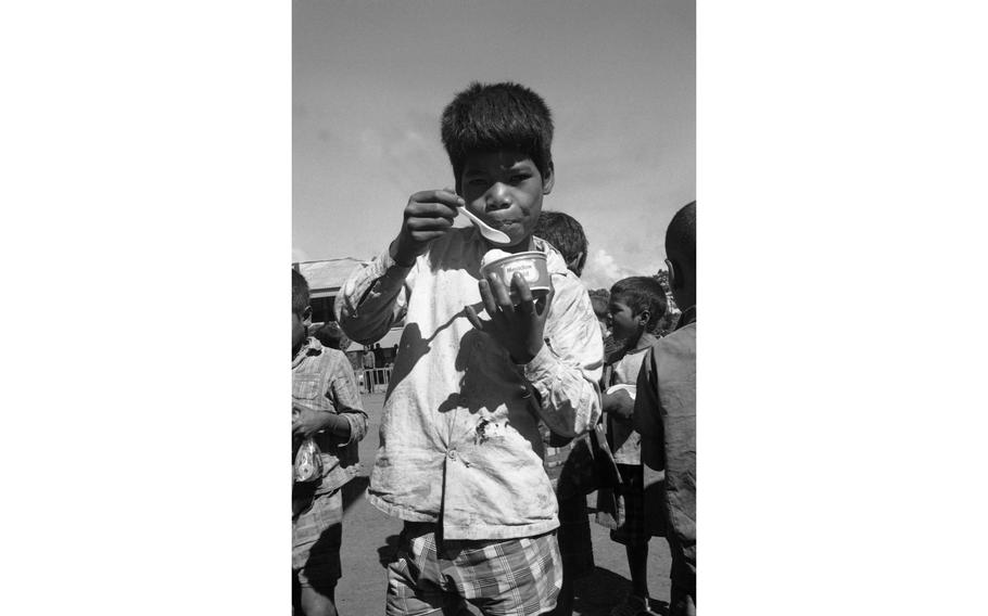 The children enjoy some ice cream in dixie cups that were passed out to them during a visit from Santa Claus.