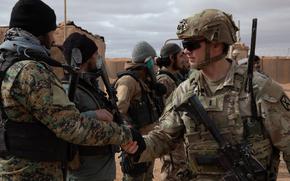 A U.S. Army Soldier, assigned to 4th Platoon, Alpha Company, 1st Battalion, 32nd Infantry Regiment, 1st Brigade Combat Team, 10th Mountain Division, Task Force Armadillo, greets a Syrian Free Army (SFA) soldier during a patrol in the Deconfliction Zone at Al-Tanf, Syria, on Dec. 28, 2024. The Coalition advises, assists and supports partner forces to ensure the lasting defeat of ISIS and radical extremist ideologies. The Coalition will also continue working with the SFA to enable the safety and security of civilians and partner forces. (U.S. Army photo by Sgt. Trenton Pallone)