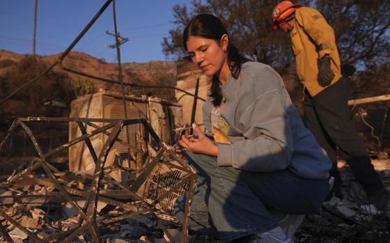 FILE - Ella Venne, left, searches through the remnants of her family's home destroyed by the Eaton Fire in Altadena, Calif., Saturday, Jan. 11, 2025. (AP Photo/Mark J. Terrill, File)