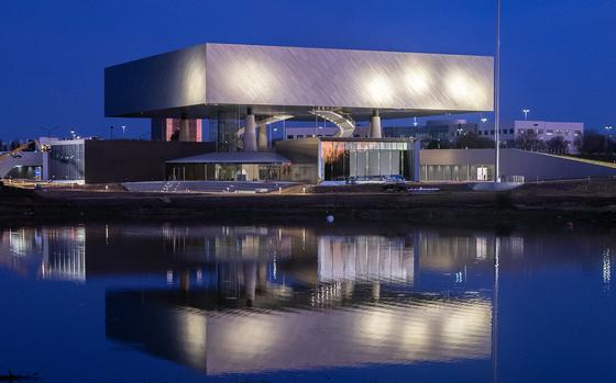 A building near a body of water against a dark blue sky.