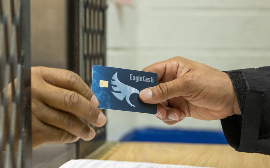 An EagleCash card is transferred from one hand to another.