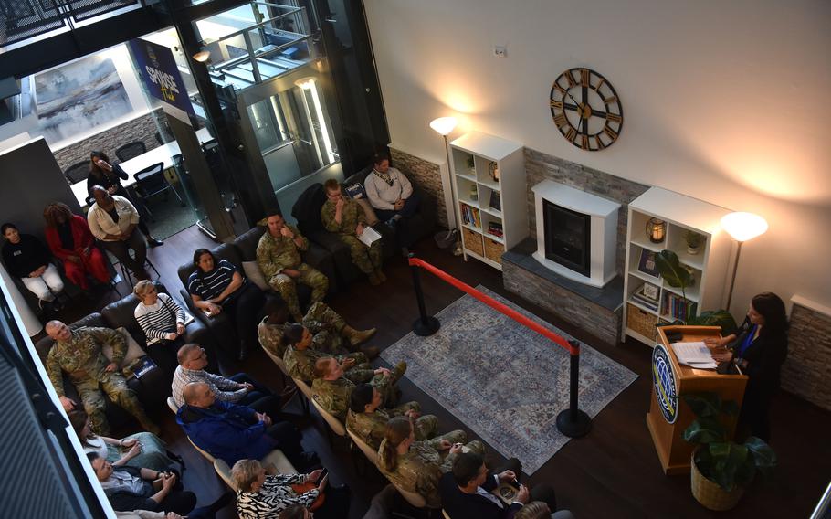 The Military Family Readiness Center flight chief stands at a podium discussing the origin of the spouse hub at its grand opening.