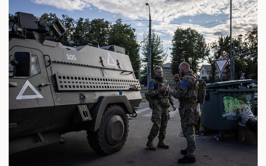 Soldiers drink coffee between tasks in a petrol station near Sumy.