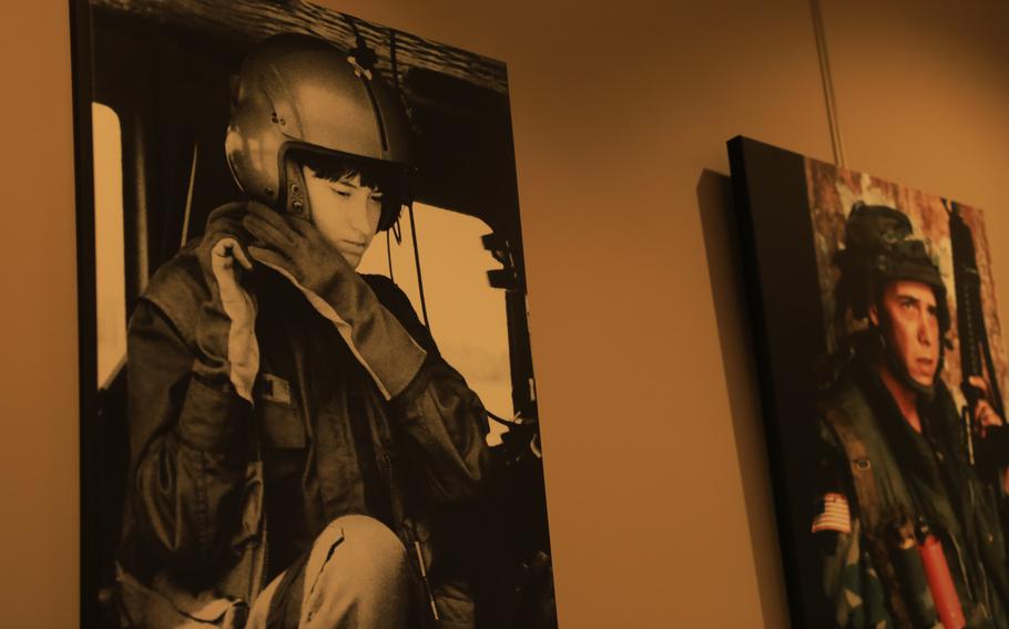 A photograph of a military aviator in flight gear hangs on the wall of a museum.